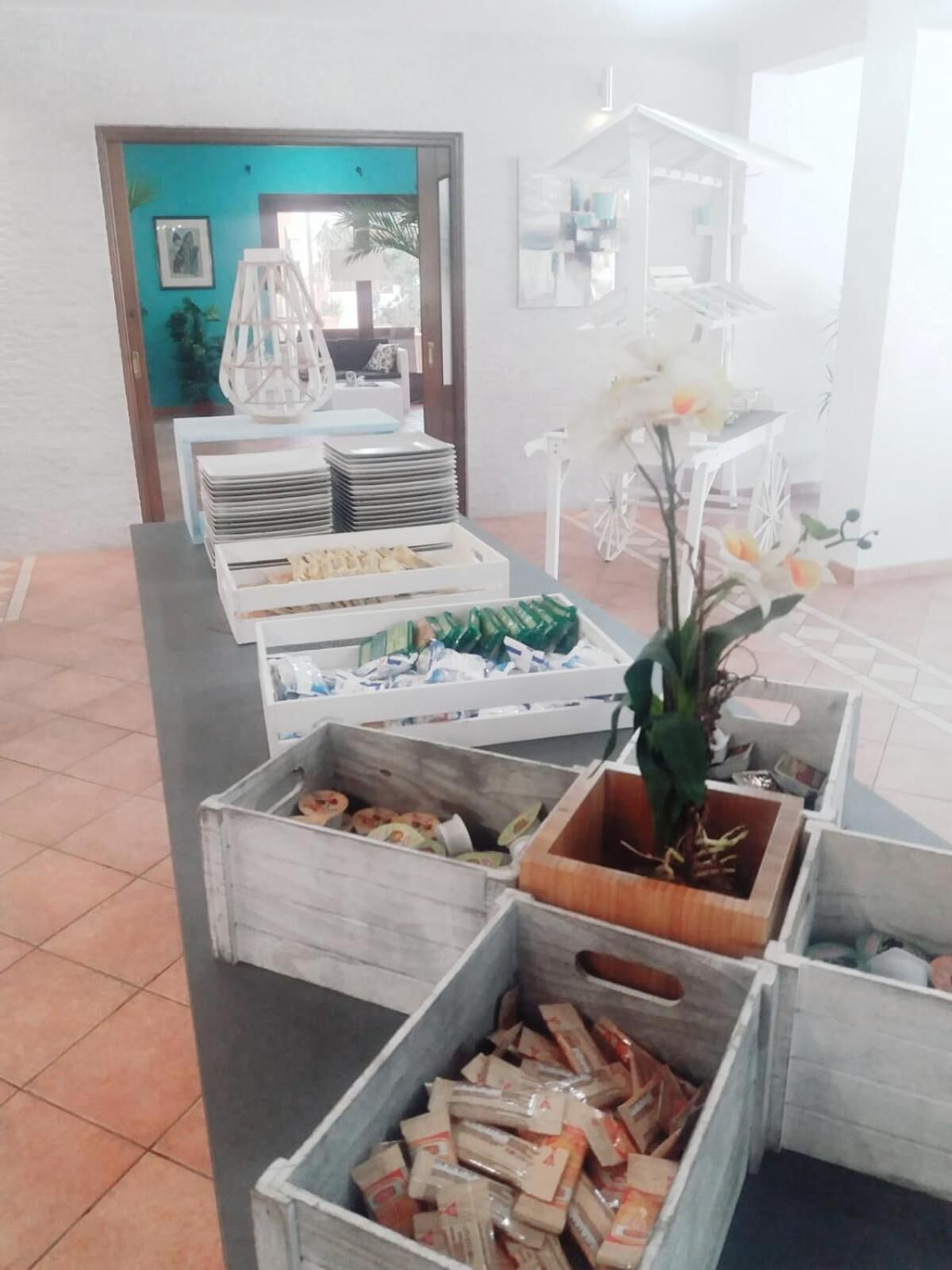 Una mesa de buffet con diversos alimentos y un centro de mesa decorativo con una orquídea.