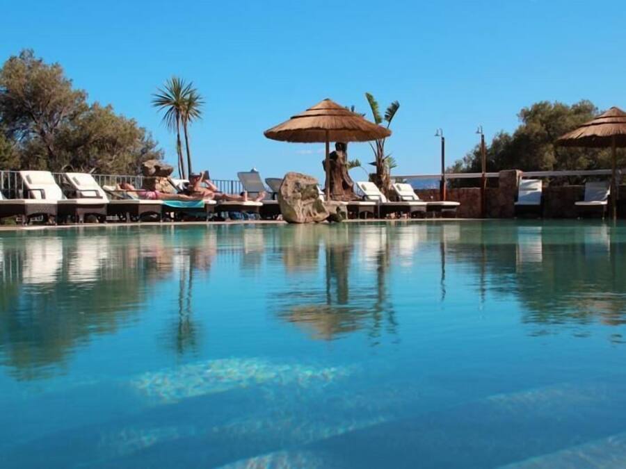 Una piscina al aire libre, sillones reclinables de piscina