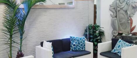 A modern living room with a sofa set, a coffee table, and a decorative sculpture.
