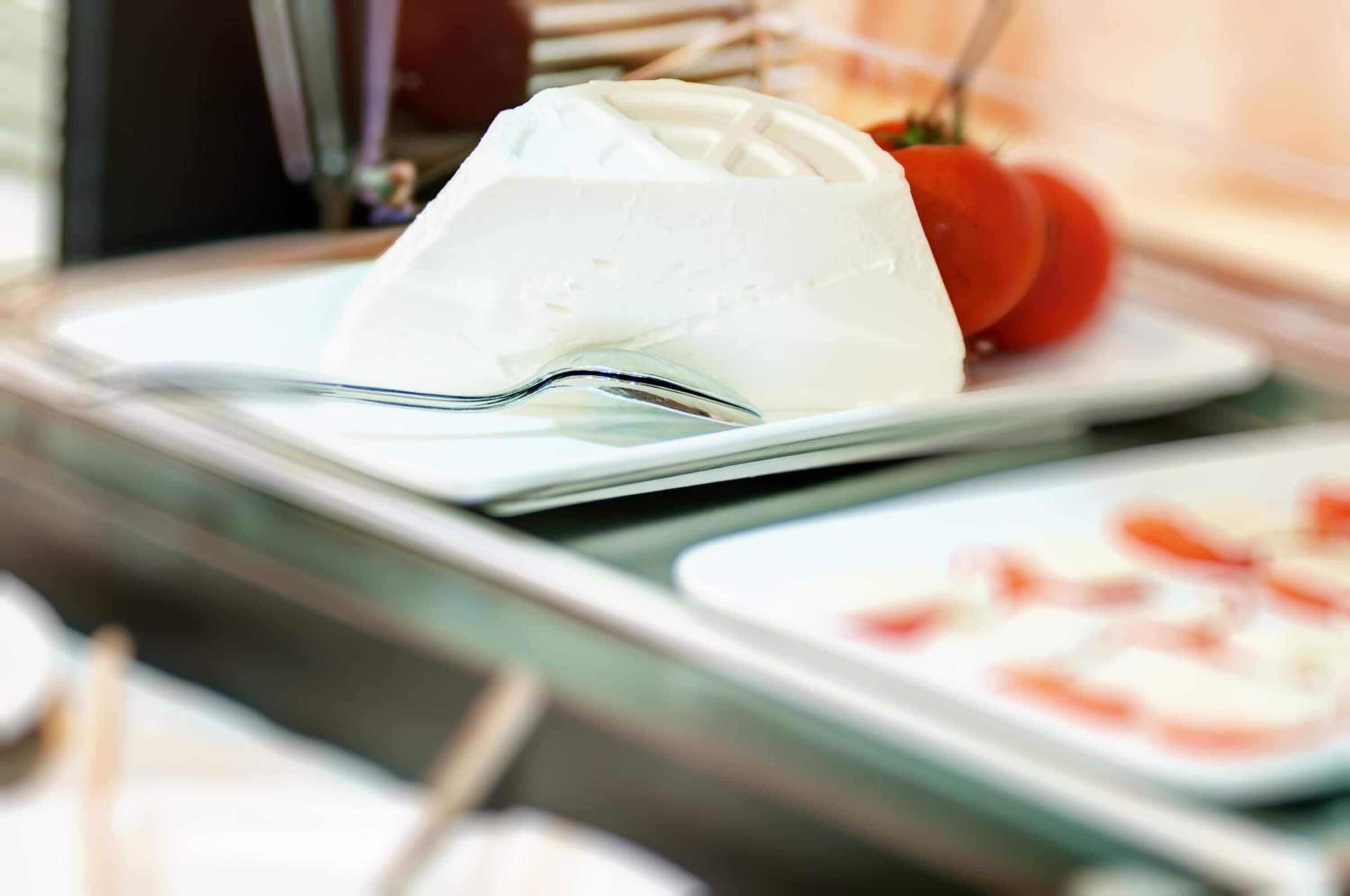 A white cheese on a plate with a fork beside it.