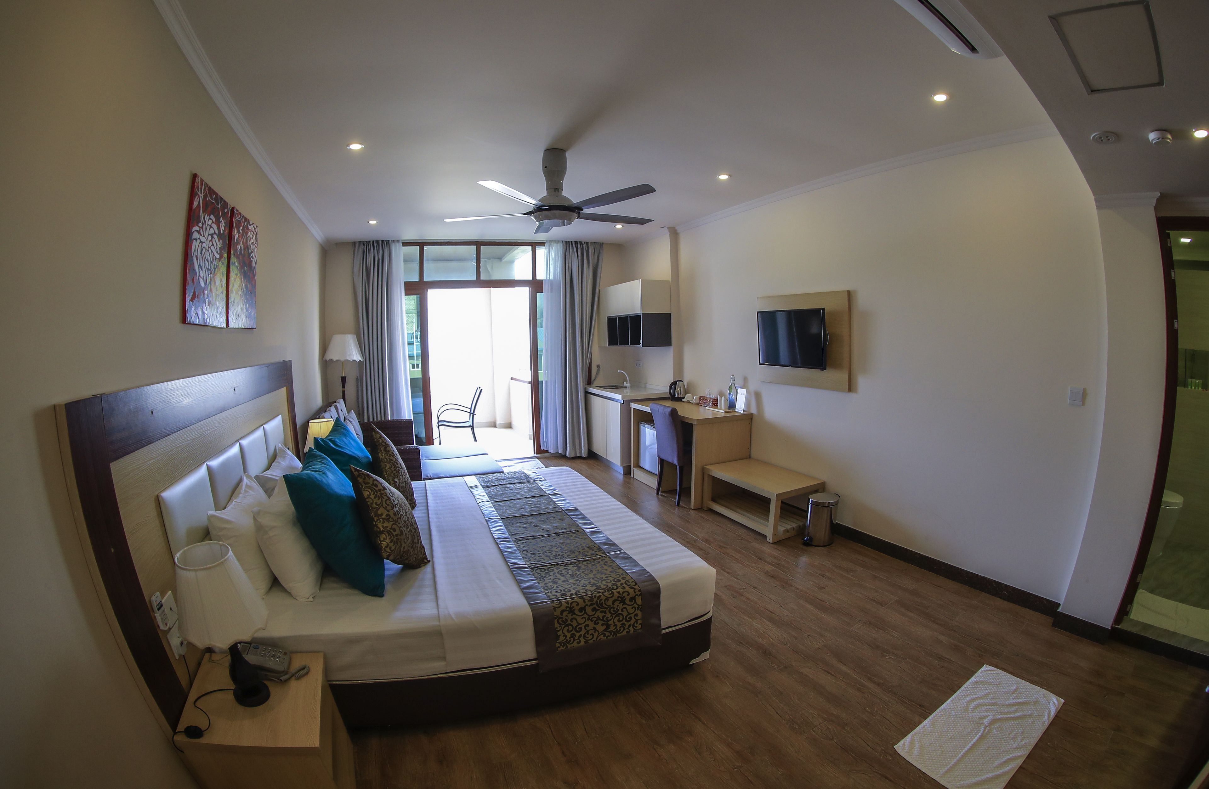 A hotel room with a bed, desk, and TV.