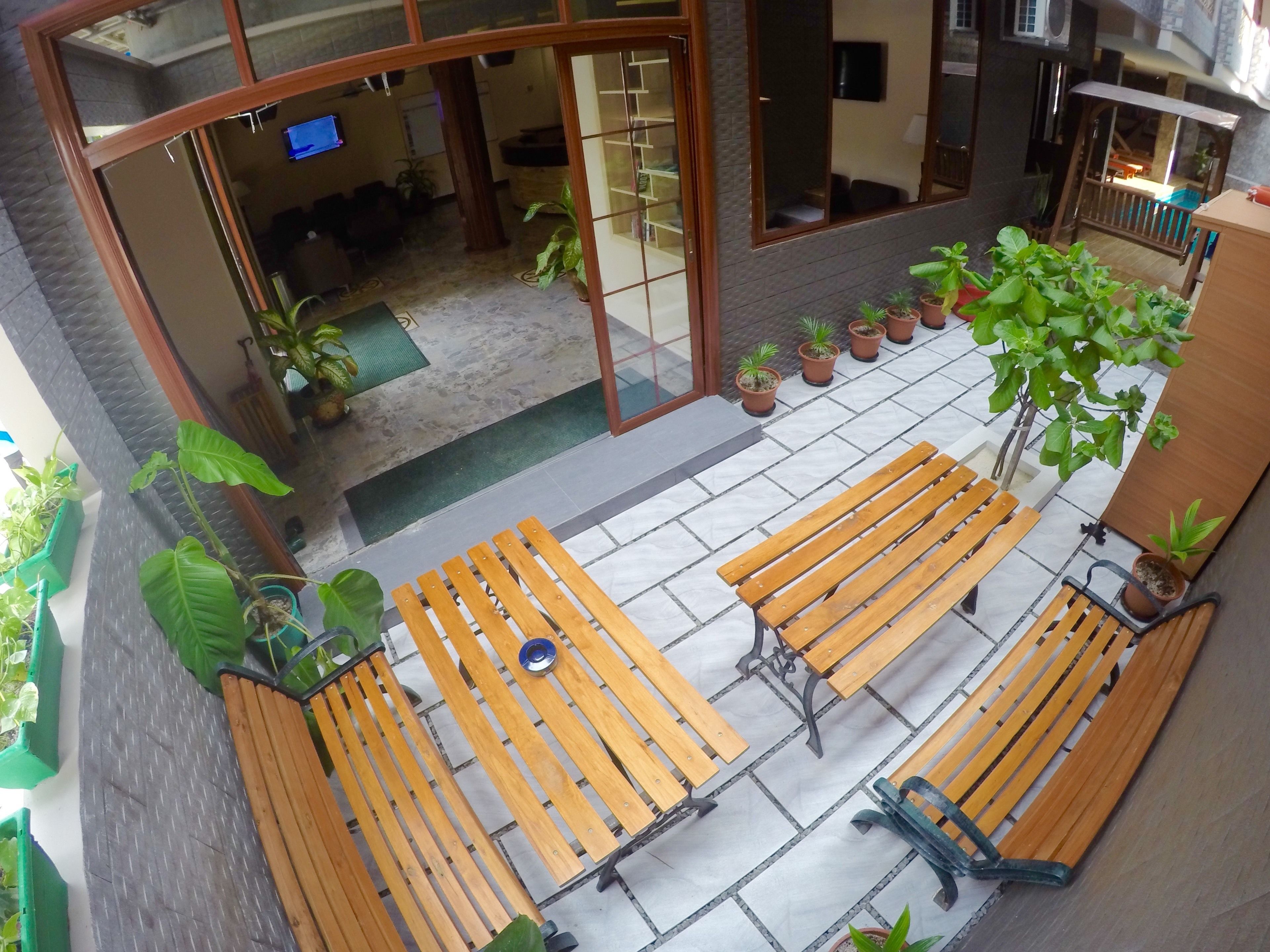 Un espacio al aire libre con bancos de madera y plantas en macetas.