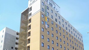 Un edificio de hotel de varios pisos con un llamativo letrero que dice 'HOTEL' en la parte superior.