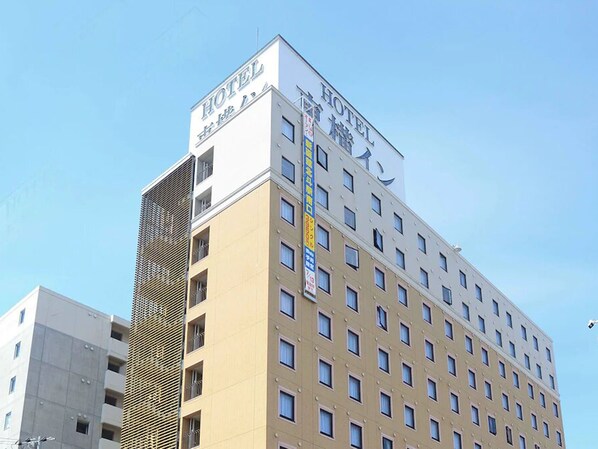Un edificio de hotel de varios pisos con un llamativo letrero que dice 'HOTEL' en la parte superior.