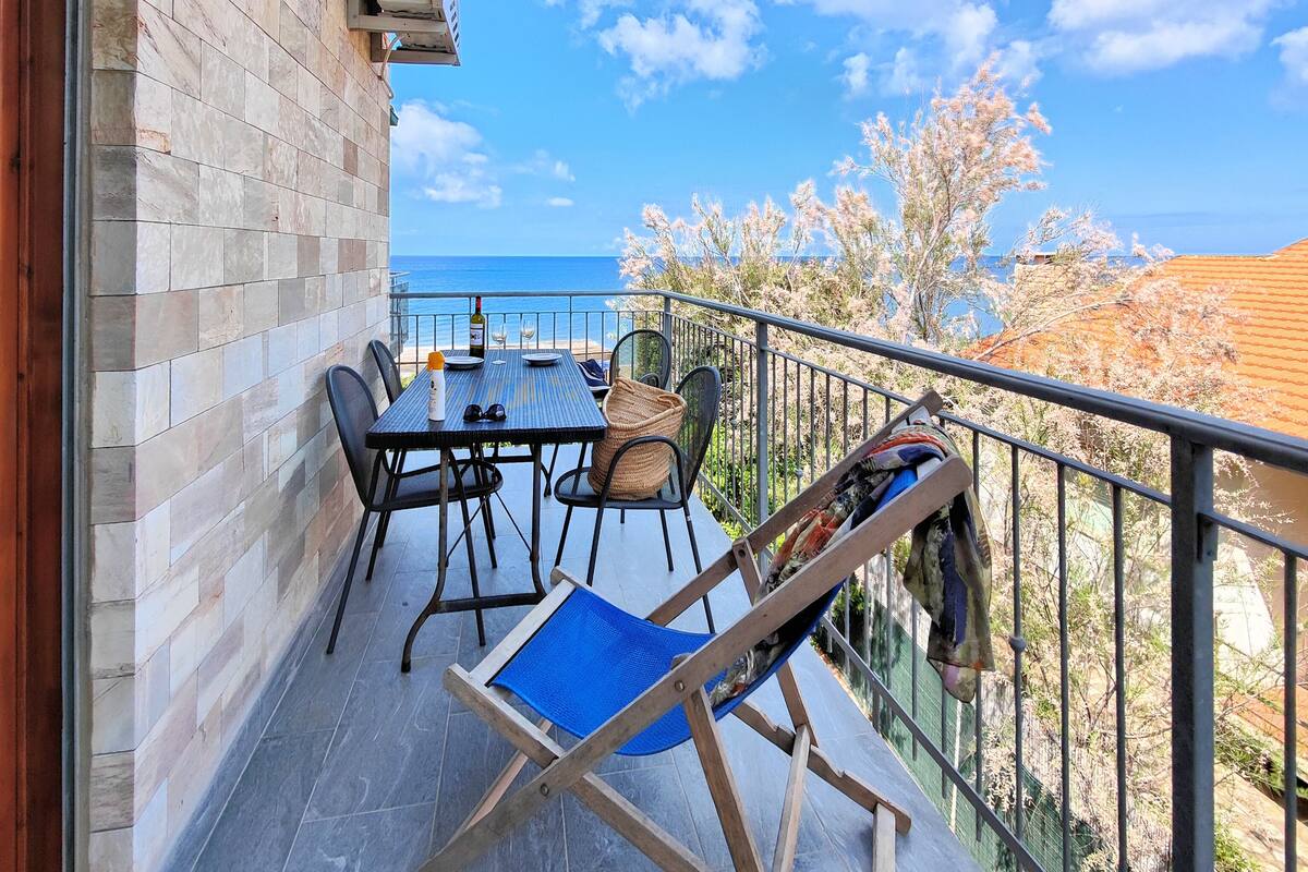A balcony with a table, chairs, and a blue chair.