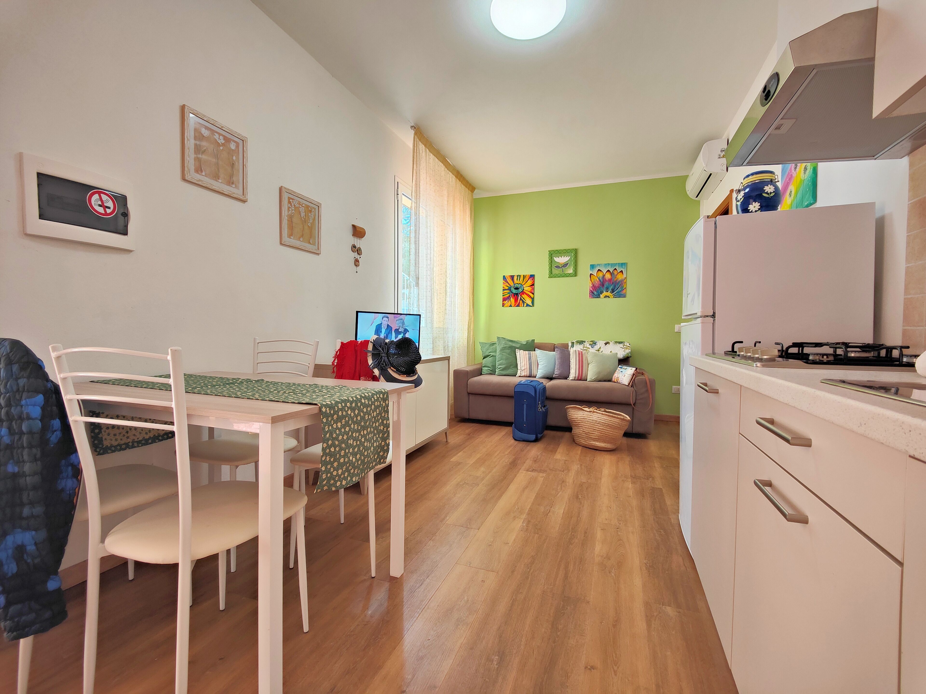 A compact living space with a dining area, kitchenette, and a sofa.
