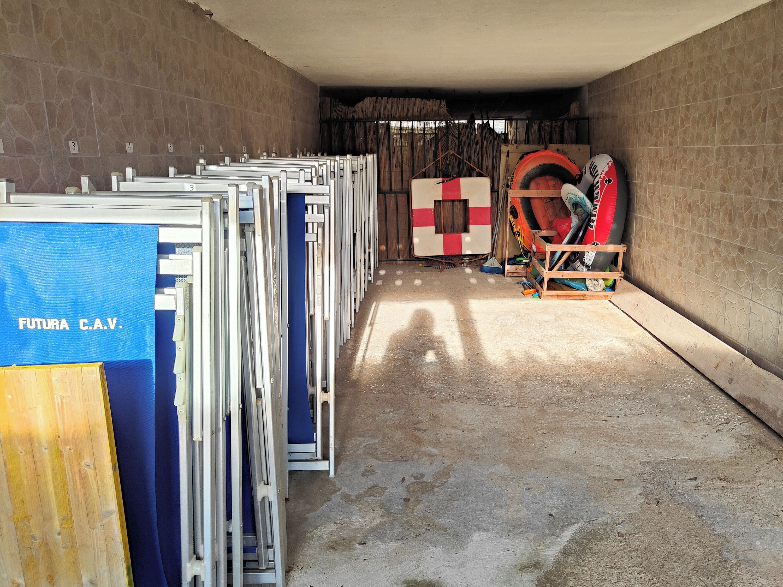 A hallway with metal gates labeled 'FUTURA C.A.V.' and a large inflatable structure in the background.