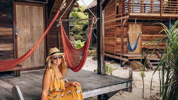 A wooden building with a balcony and a hammock.