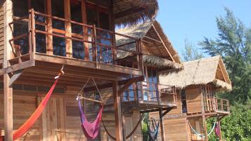 Escape to a serene retreat surrounded by lush vegetation, with a balcony offering a peaceful spot to unwind.