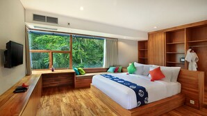 Un dormitorio moderno con una cama grande, suelo de madera, un banco empotrado, un televisor y una ventana con vistas a zonas verdes.