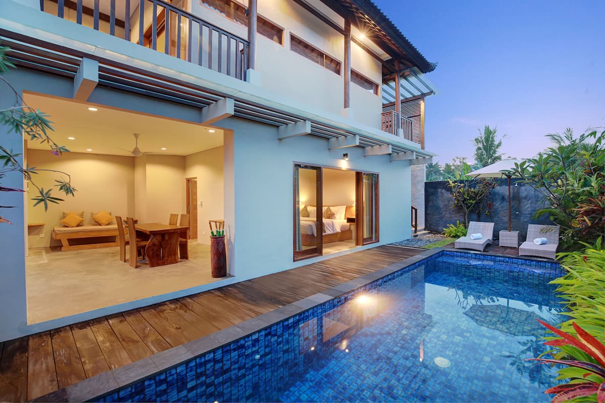 A modern house with a swimming pool, a dining area, and a balcony.