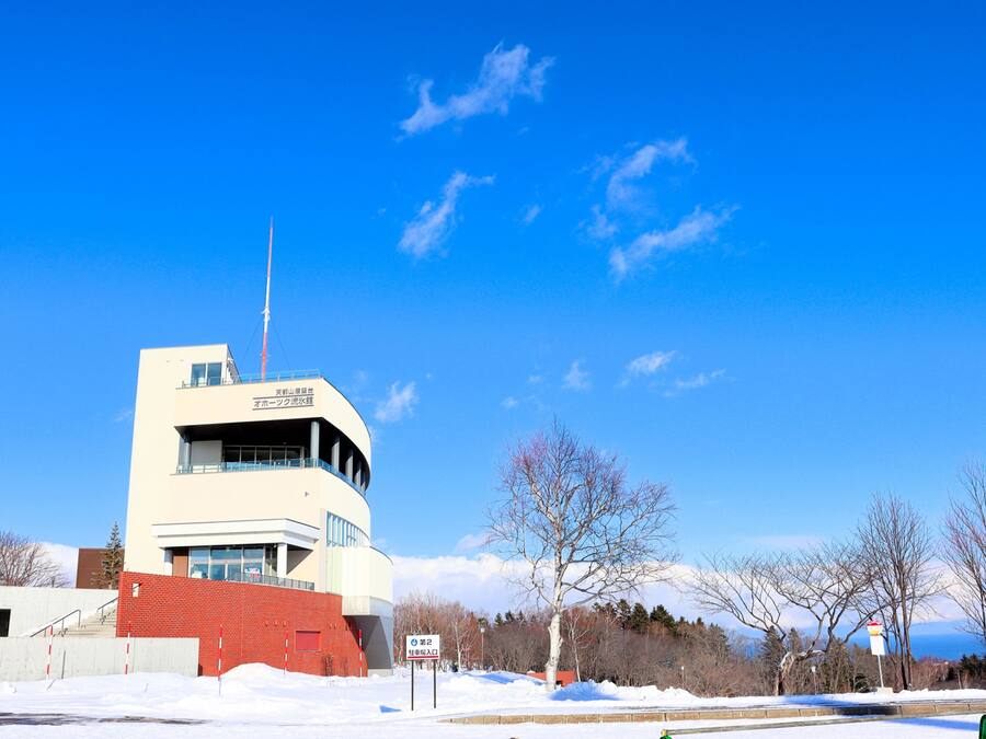 A modern building with a flat roof and a visible antenna.