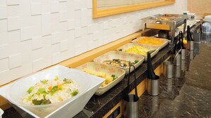 Montaje de bufé con diversos platos de comida y utensilios.