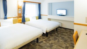 Habitación de hotel con dos camas, un escritorio, un televisor y una ventana con cortinas.