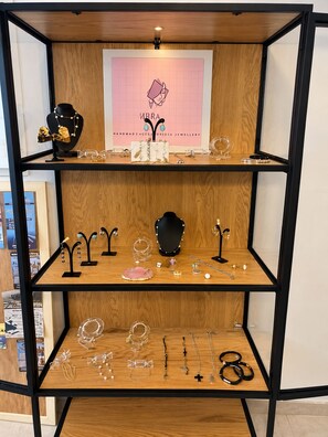 A jewelry display with multiple shelves, each holding various pieces of jewelry. - Koukounari Apartments (Agistri)