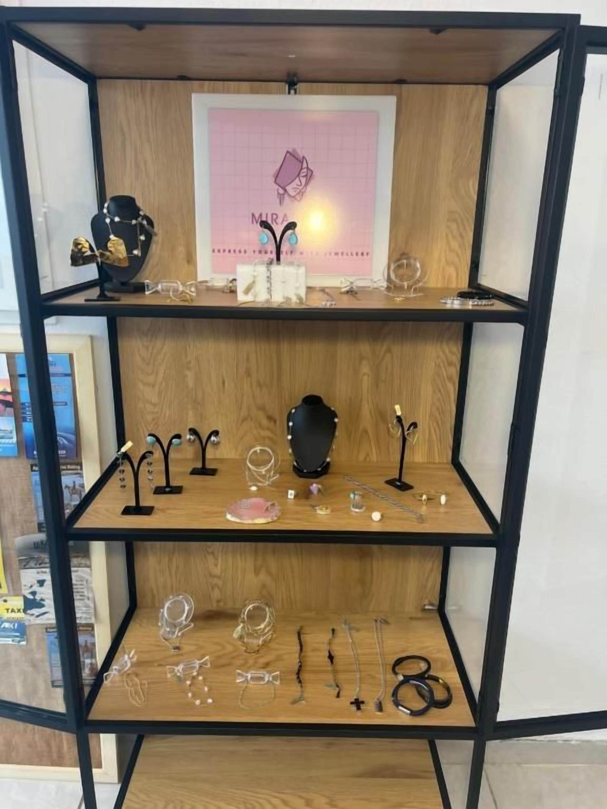 A multi-tiered jewelry display with various necklaces and earrings.
