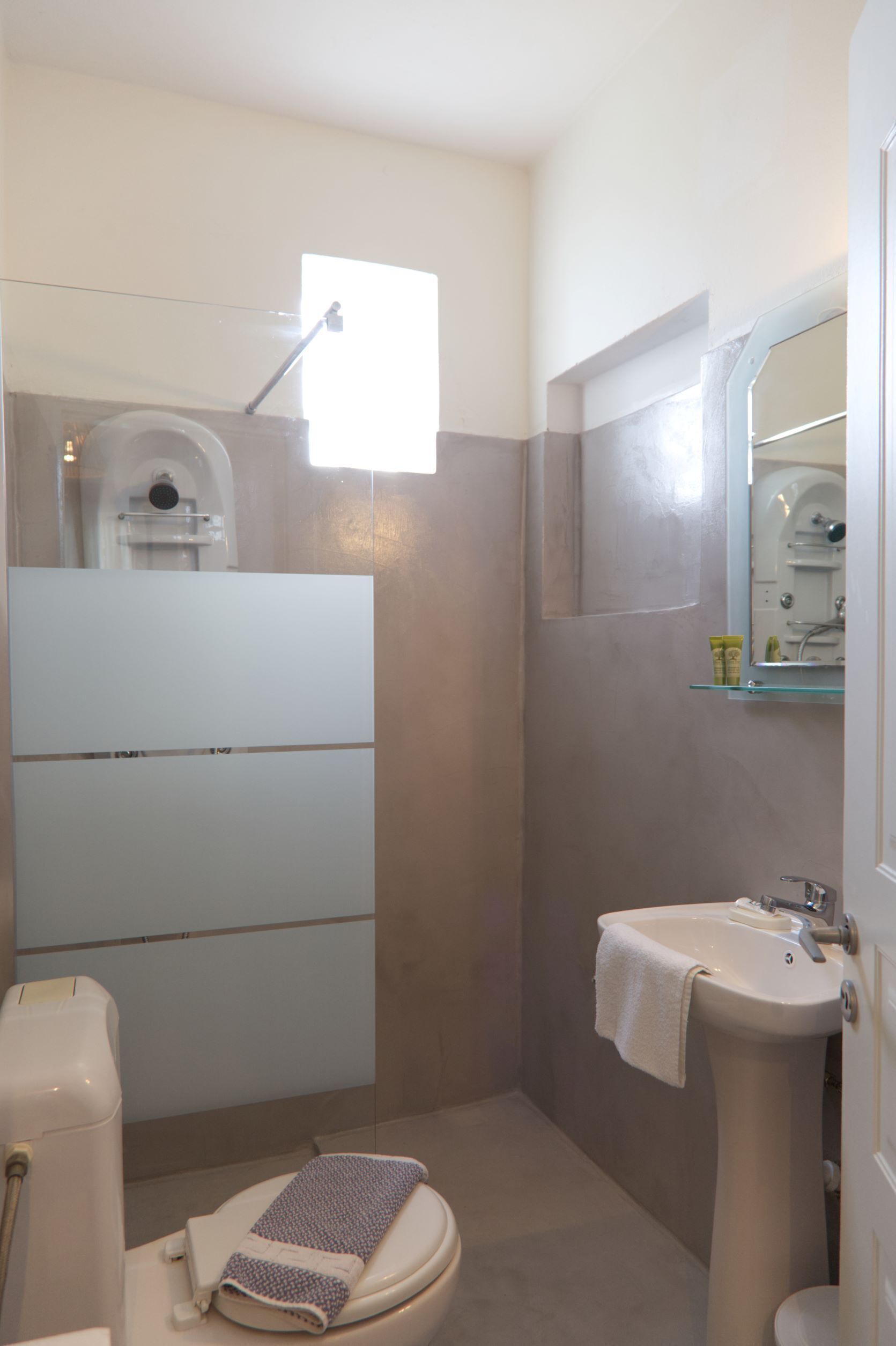Une salle de bain avec des toilettes, un lavabo et une douche.