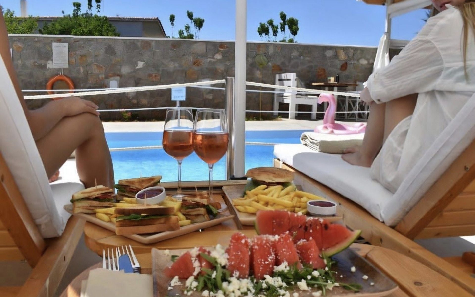 Un tavolo da pranzo con cibo e bevande, vista piscina.