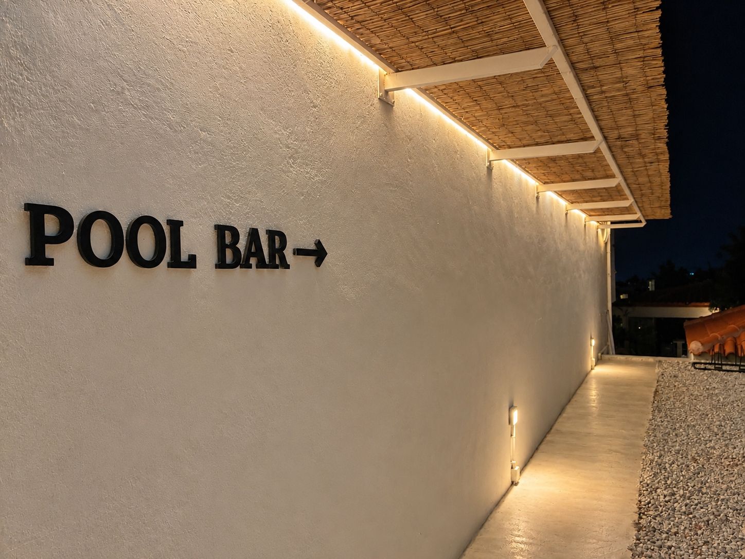 Een muur met een bord dat de richting van een poolbar aangeeft.