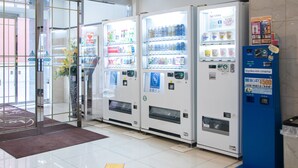 A row of vending machines with various beverages and snacks, a blue information kiosk, and a glass door entrance. - Toyoko Inn Hokkaido Sapporo Susukino Minami (Sapporo)