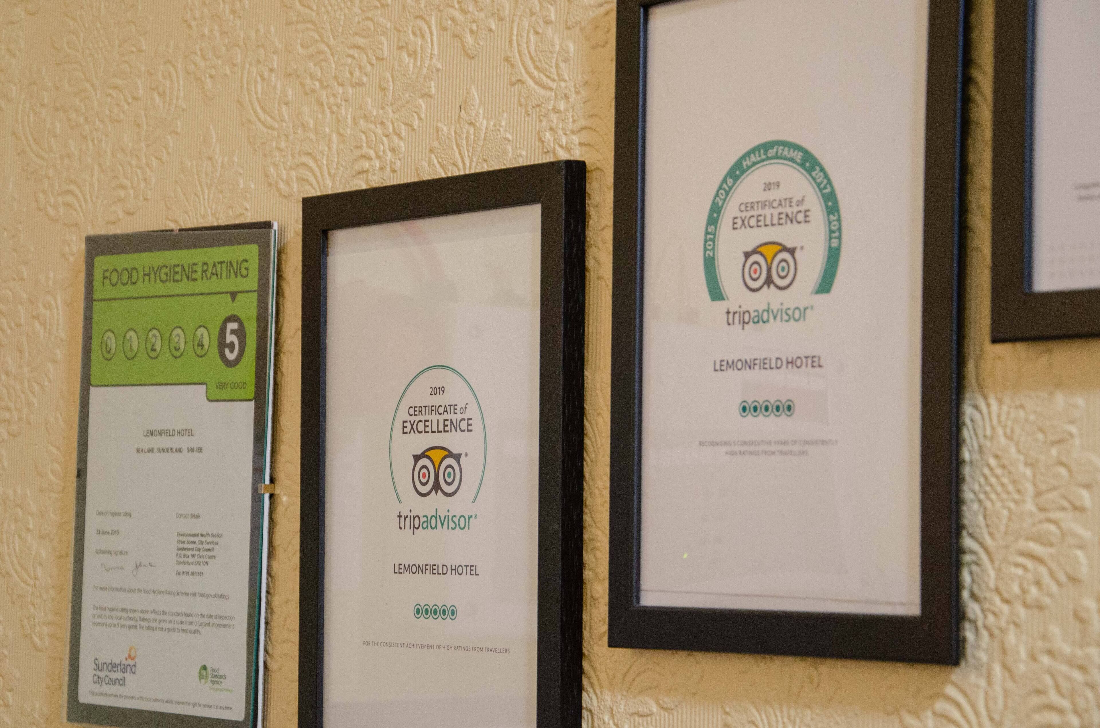 Three framed certificates on a wall.
