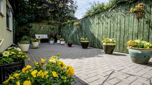 A paved patio with potted plants and a wooden fence. - Lemonfield Hotel (Sunderland)