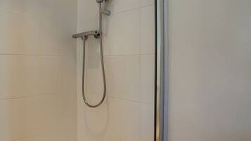A shower with a handheld showerhead and a handheld shower attachment.