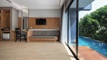 A modern living room with a sofa, a television, and a dining area with chairs and a table.