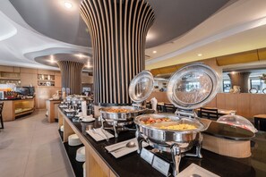 A buffet setup with multiple food stations, including a visible label for 'Pineapple Fried Rice'. - Ava Sea Krabi Resort (Krabi)
