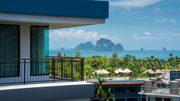 A modern building with a balcony overlooking a tropical beach and clear blue sea. - Ava Sea Krabi Resort (Krabi)