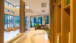 A spacious lobby with large windows, a central seating area with sofas, and a wooden reception desk. - Ava Sea Krabi Resort (Krabi)