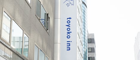 Un edificio con un letrero de 'Toyoko Inn' en un poste.