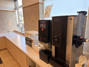 Een koffieapparaat en een waterdispenser in een hotelkamer.