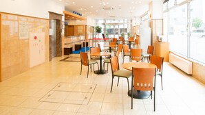 A spacious indoor area with multiple tables and chairs, a reception desk, and a large window providing a view of the outside. - Toyoko Inn Hokkaido Asahikawa Ekimae Ichijo Dori (Asahikawa)