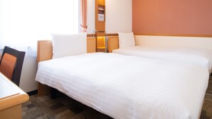 A hotel room with two beds, a desk, and a window with curtains. - Toyoko Inn Hokkaido Asahikawa Ekimae Ichijo Dori (Asahikawa)