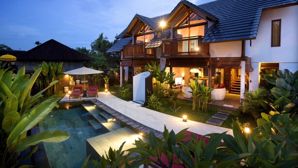 A modern house with a swimming pool, outdoor seating, and a well-lit garden area. - Villa LeoNora (Ubud)
