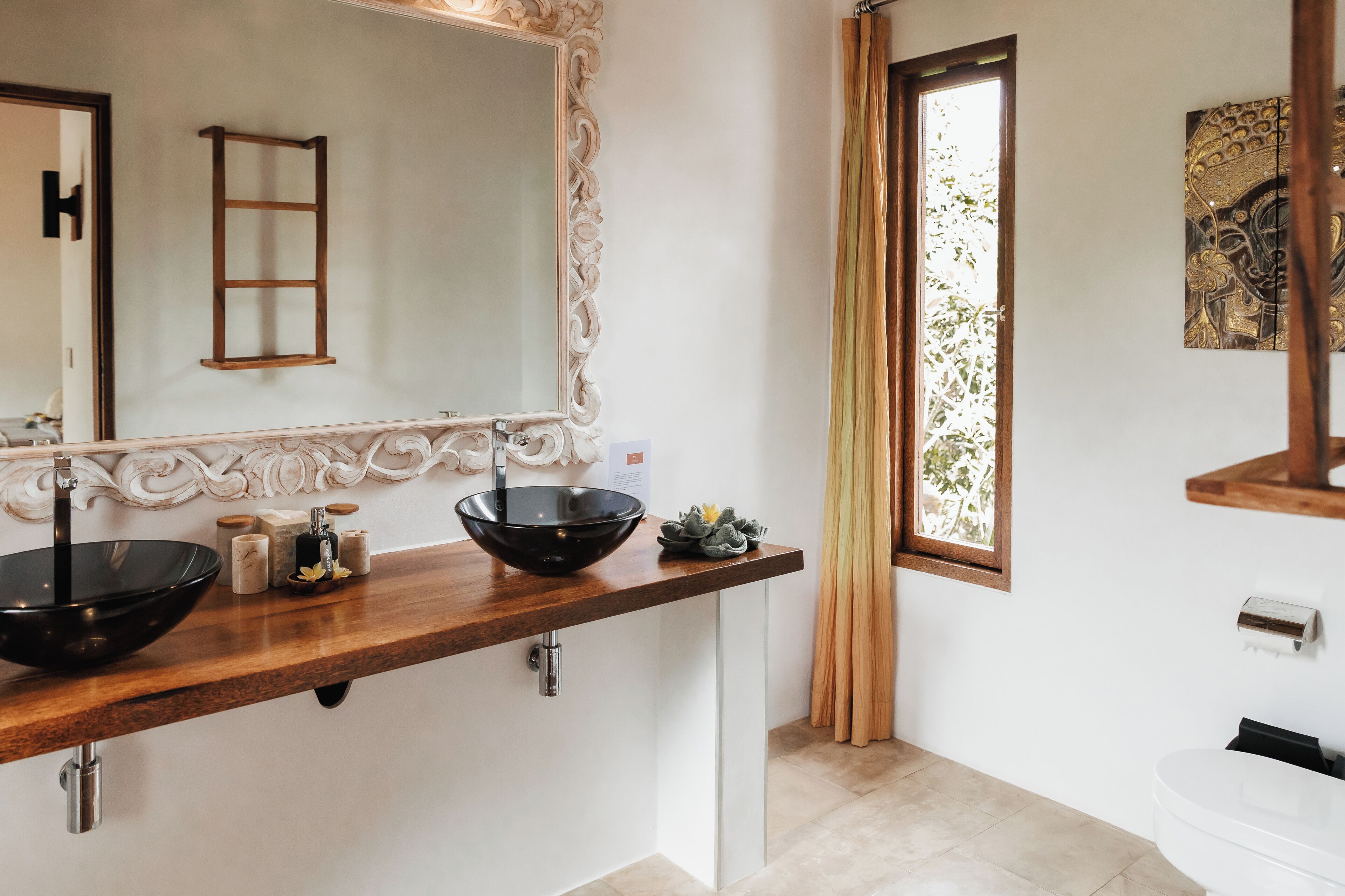 A bathroom with two sinks, a large mirror, and a window with curtains.