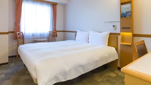 A hotel room with a large bed, a small table, and a chair. - Toyoko Inn Hokkaido Kushiro Juji Gai (Kushiro)