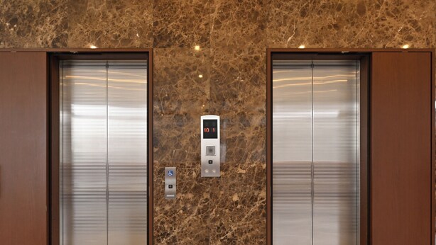 A pair of elevator doors with a digital display and accessibility button in the center. - Toyoko Inn Hokkaido Kushiro Juji Gai (Kushiro)