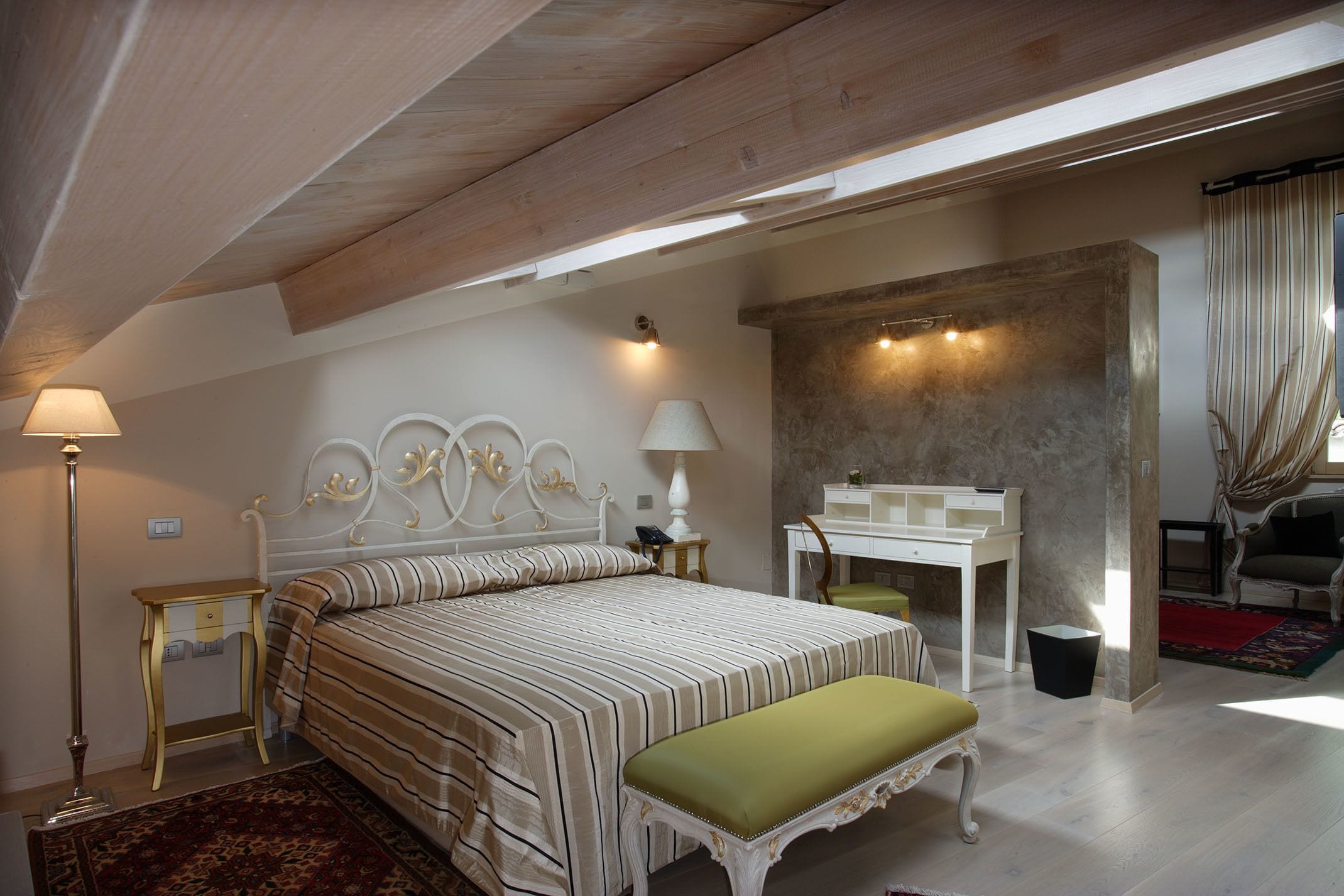 Un dormitorio con cama, mesitas de noche, un escritorio y una silla.
