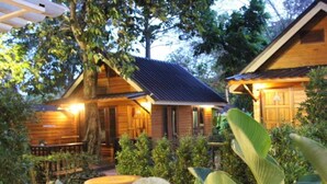 A wooden cabin with a porch and a dining area.