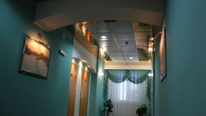 A hallway with teal walls, a framed picture, and a door.