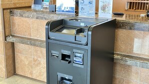 A self-service kiosk with multiple card readers and a cash slot, located in a lobby with a marble floor and a counter with a digital display. - Toyoko Inn Hokkaido Tomakomai Ekimae (Tomakomai)