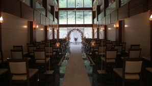 A spacious hall with rows of chairs and a central aisle leading to a decorative archway. - Kilpa Hotel (Çaykara)