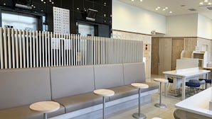 A modern interior with a seating area, tables, and a counter. - Toyoko Inn Hokkaido Asahikawa Station Higashi (Asahikawa)
