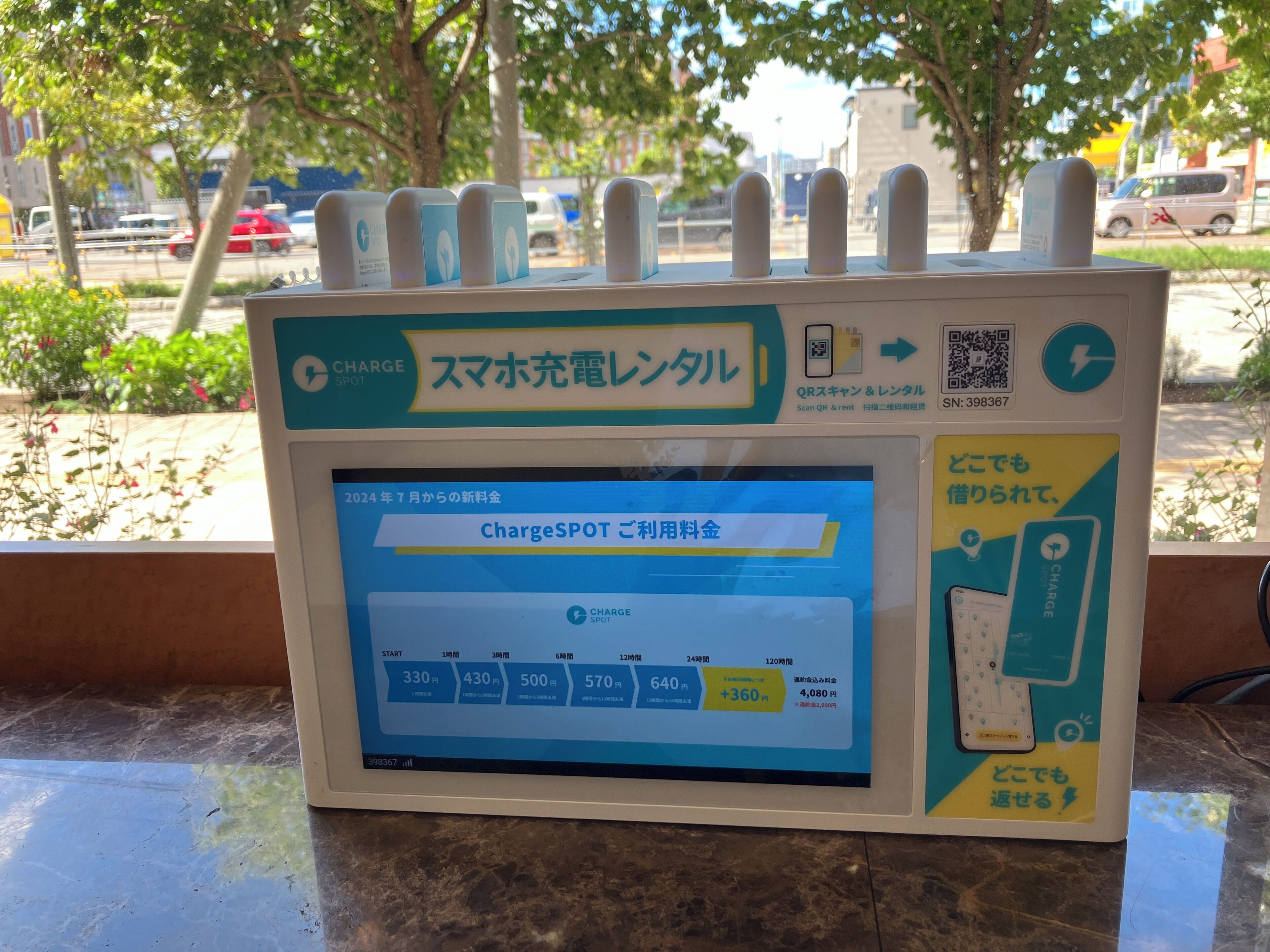 A ChargeSPOT charging station with a digital display and QR code for payment.