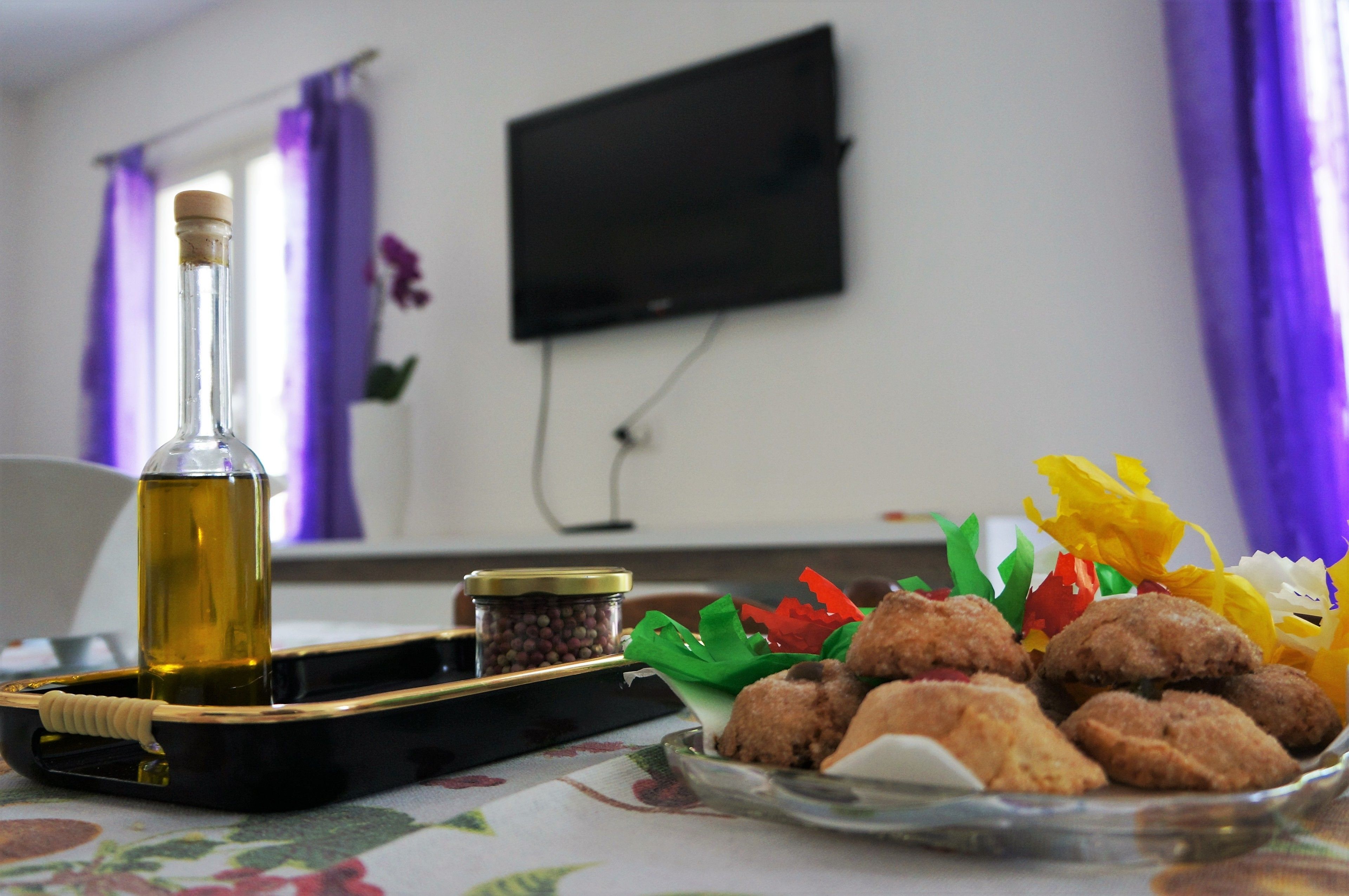A table with a bottle of oil, a tray, and a plate of fried food.