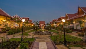 Un resort con varias edificaciones, una fuente central y jardines bien cuidados.