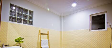 A bathroom with a bathtub, a sink, a towel rack, and a window.