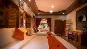 Habitación de hotel con una cama grande, un escritorio y un televisor montado en la pared.